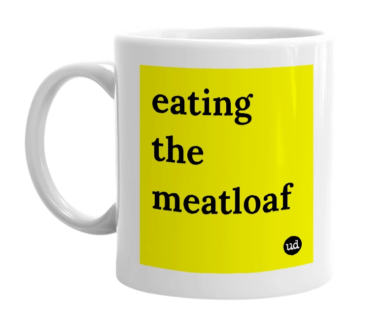 White mug with 'eating the meatloaf' in bold black letters