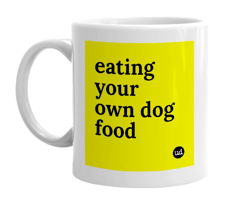 White mug with 'eating your own dog food' in bold black letters