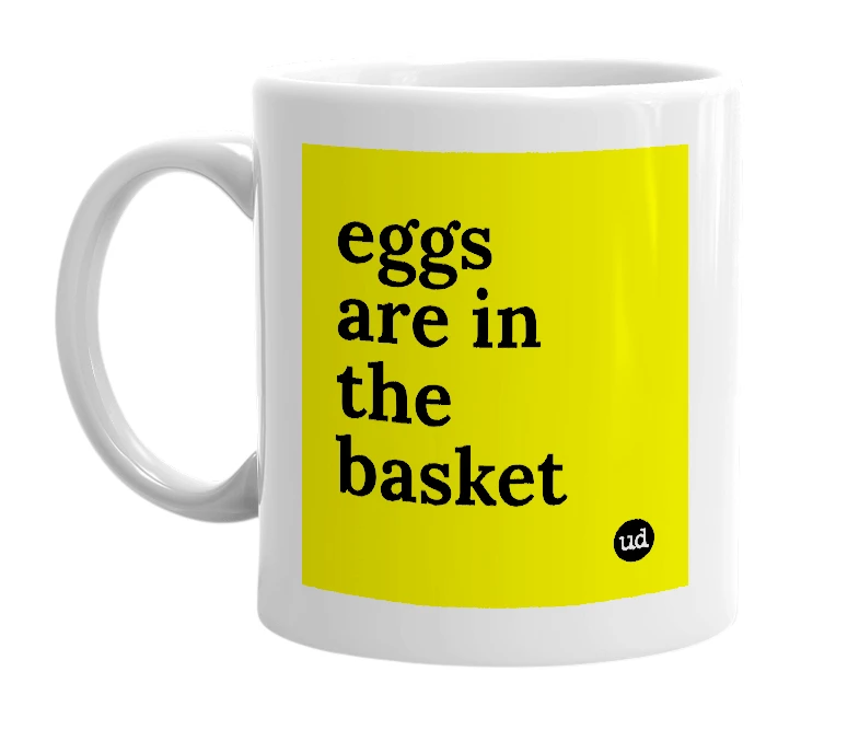 White mug with 'eggs are in the basket' in bold black letters