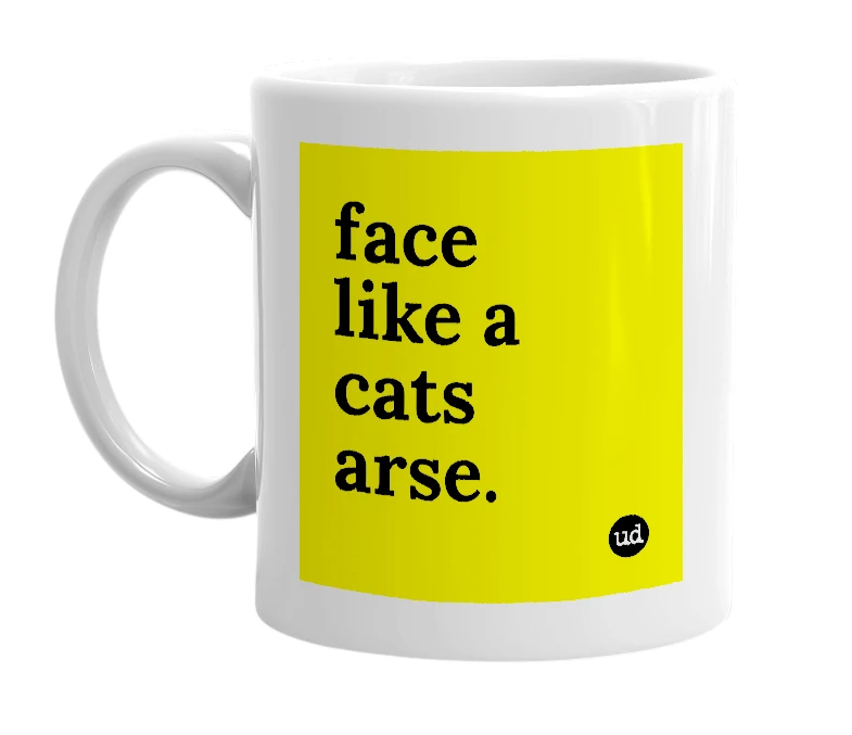 White mug with 'face like a cats arse.' in bold black letters