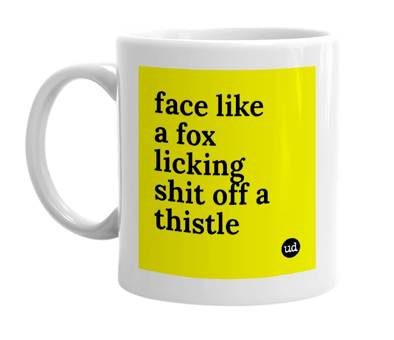 White mug with 'face like a fox licking shit off a thistle' in bold black letters