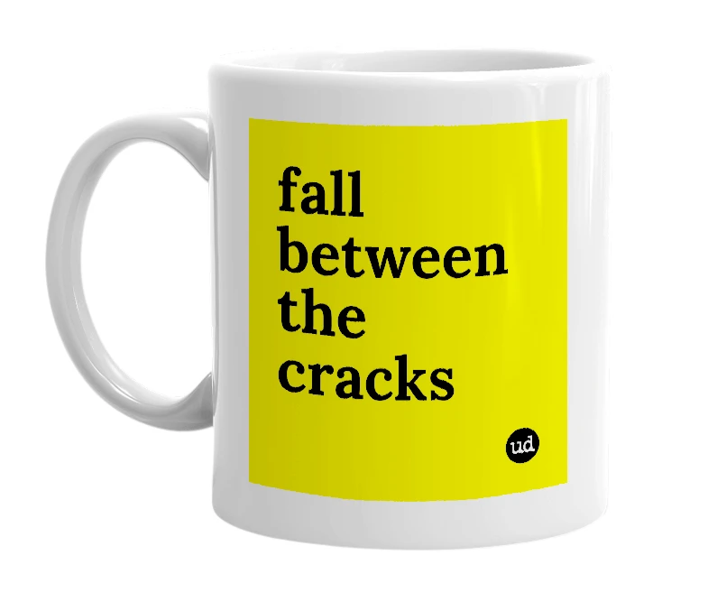 White mug with 'fall between the cracks' in bold black letters