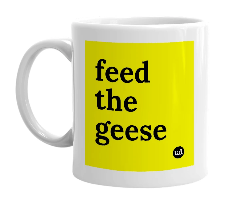 White mug with 'feed the geese' in bold black letters