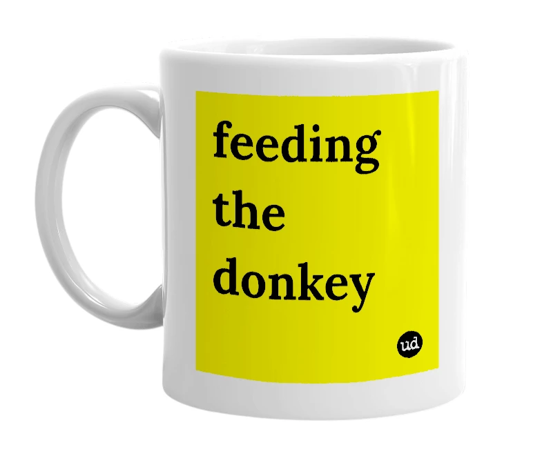 White mug with 'feeding the donkey' in bold black letters