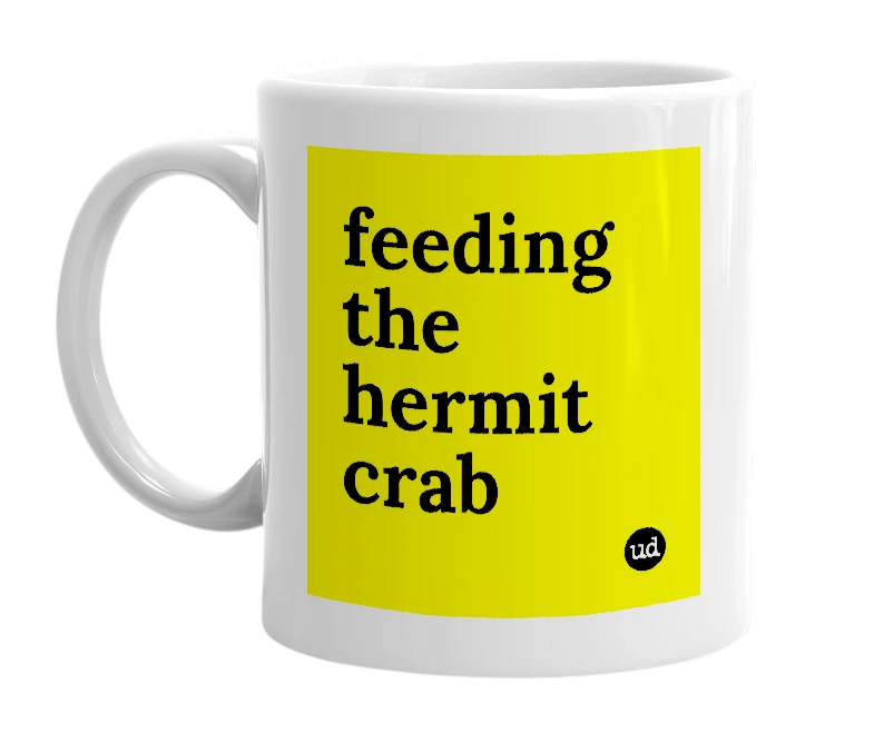White mug with 'feeding the hermit crab' in bold black letters