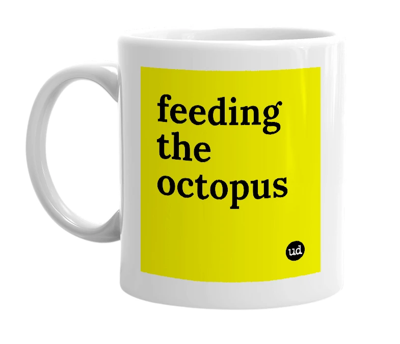 White mug with 'feeding the octopus' in bold black letters