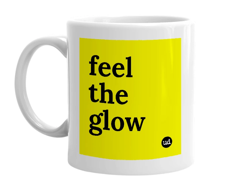 White mug with 'feel the glow' in bold black letters