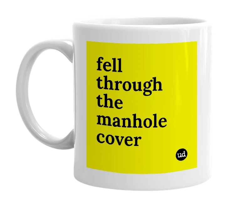 White mug with 'fell through the manhole cover' in bold black letters