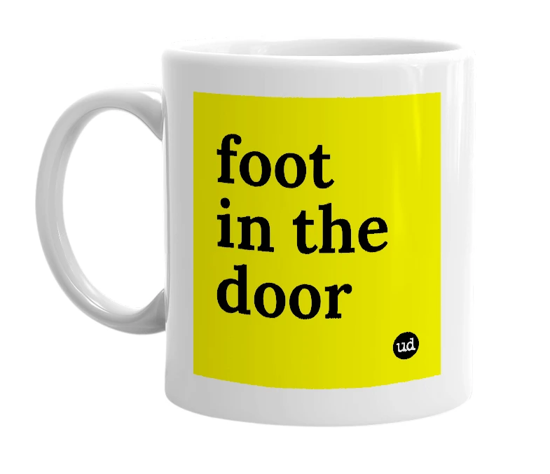 White mug with 'foot in the door' in bold black letters