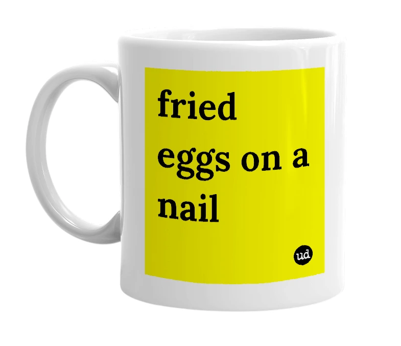 White mug with 'fried eggs on a nail' in bold black letters
