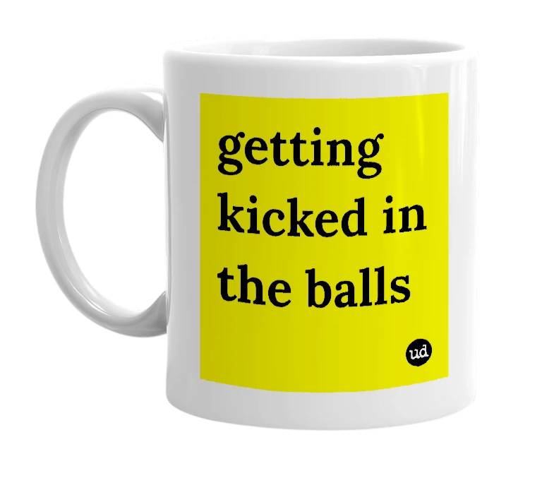White mug with 'getting kicked in the balls' in bold black letters