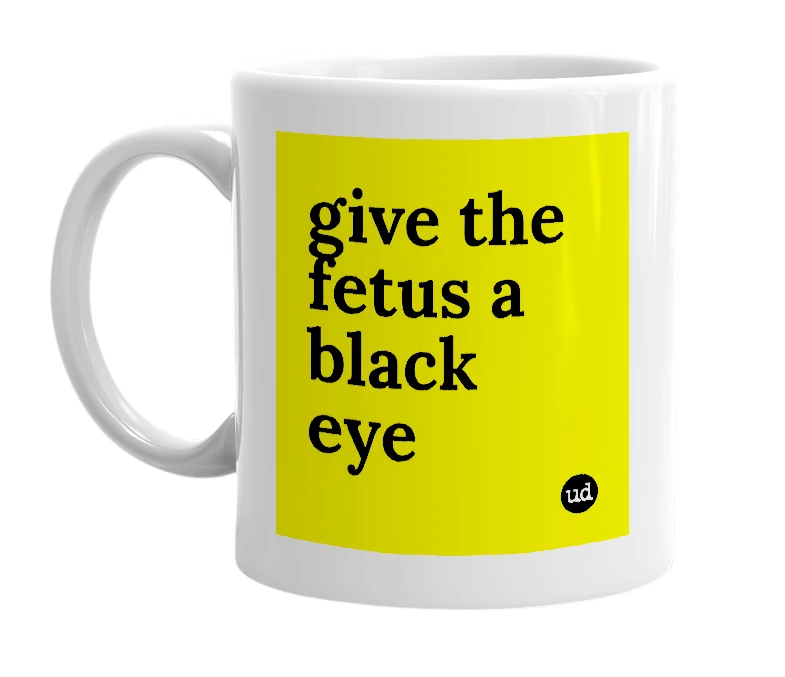 White mug with 'give the fetus a black eye' in bold black letters