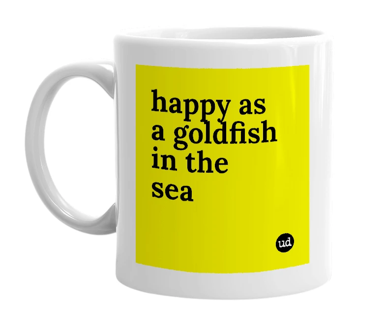 White mug with 'happy as a goldfish in the sea' in bold black letters