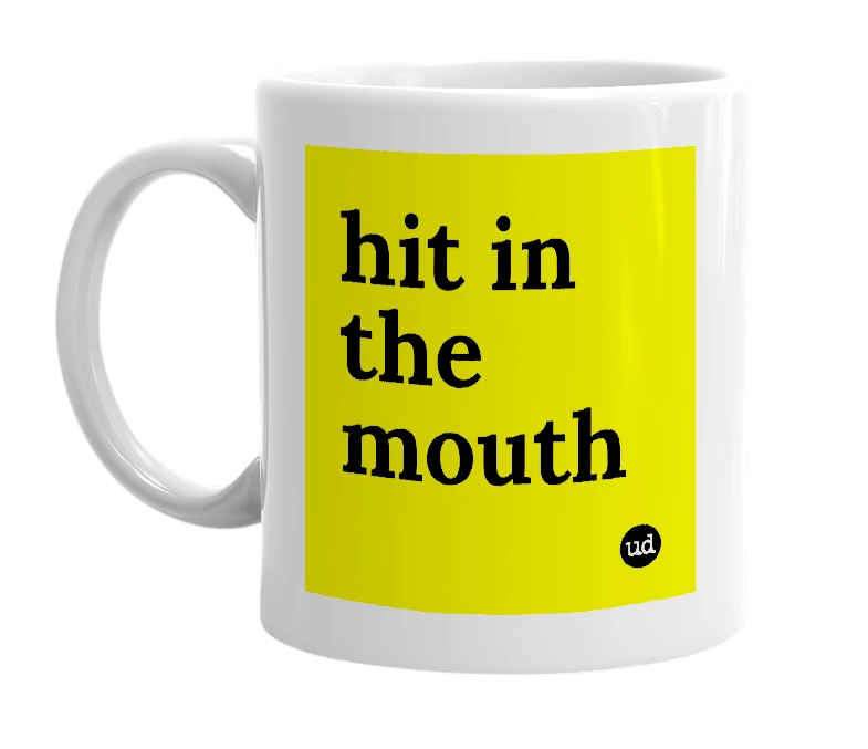 White mug with 'hit in the mouth' in bold black letters