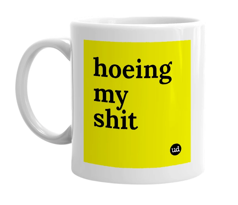 White mug with 'hoeing my shit' in bold black letters