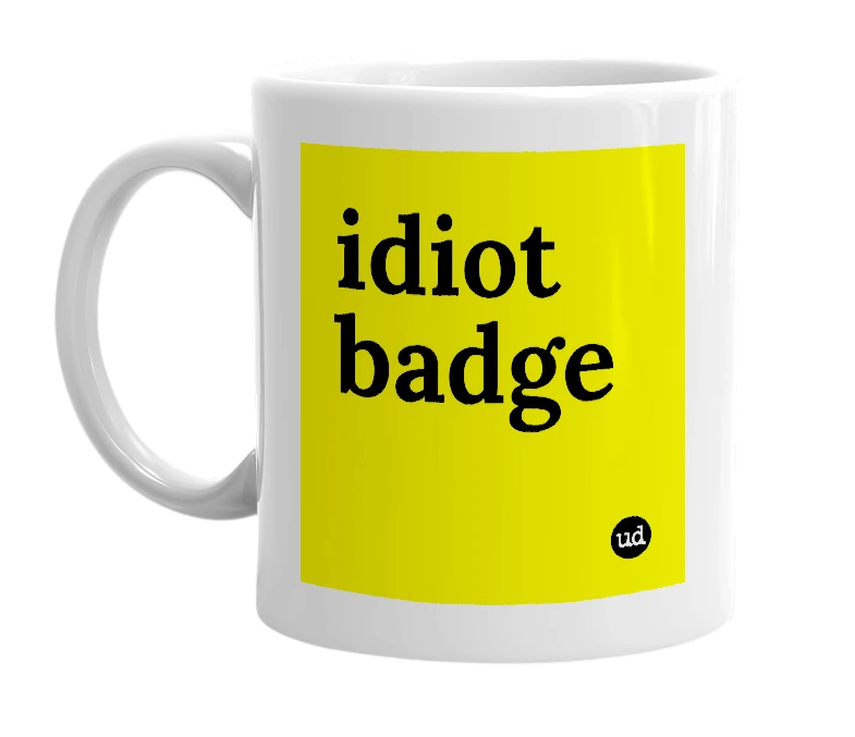 White mug with 'idiot badge' in bold black letters