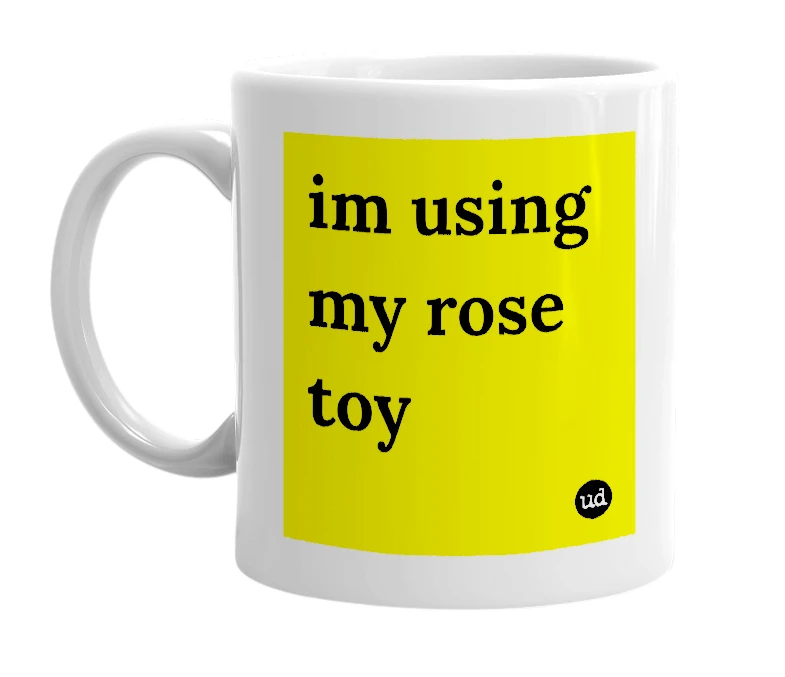 White mug with 'im using my rose toy' in bold black letters