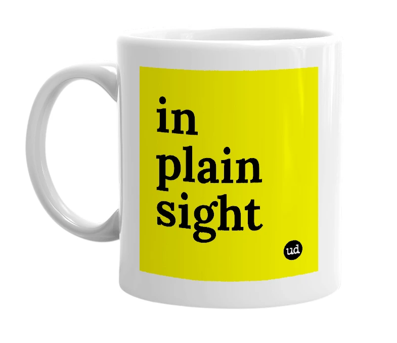 White mug with 'in plain sight' in bold black letters