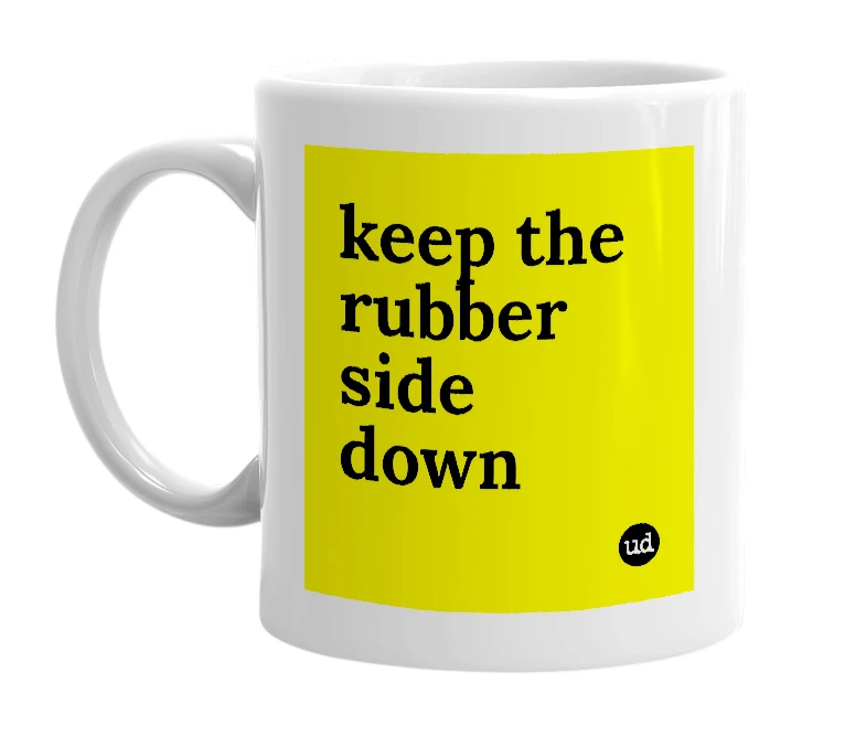 White mug with 'keep the rubber side down' in bold black letters