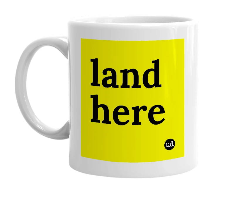 White mug with 'land here' in bold black letters