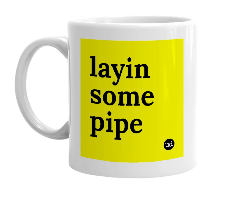 White mug with 'layin some pipe' in bold black letters