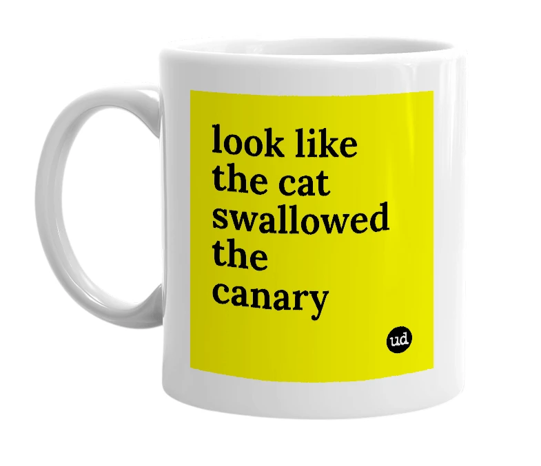 White mug with 'look like the cat swallowed the canary' in bold black letters