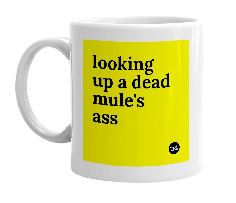 White mug with 'looking up a dead mule's ass' in bold black letters
