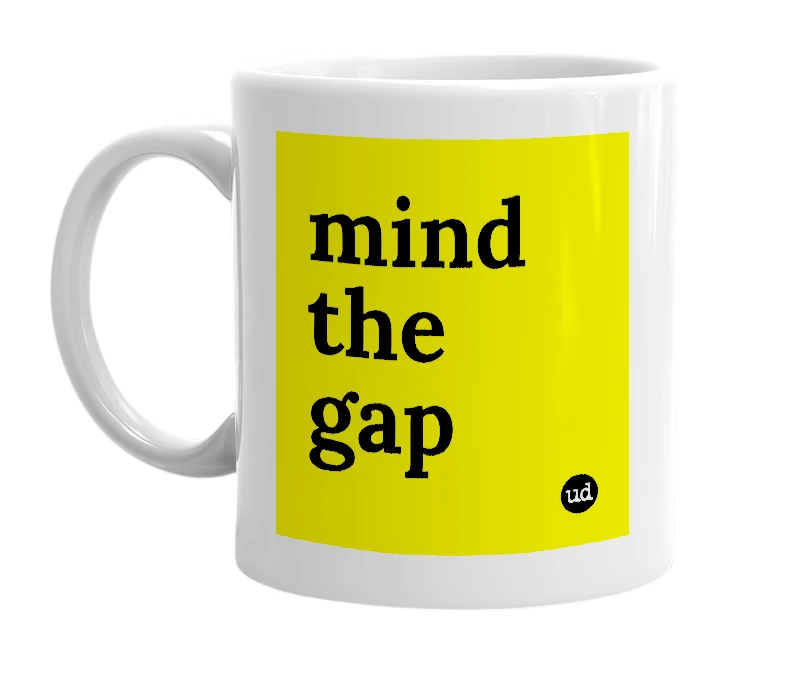 White mug with 'mind the gap' in bold black letters