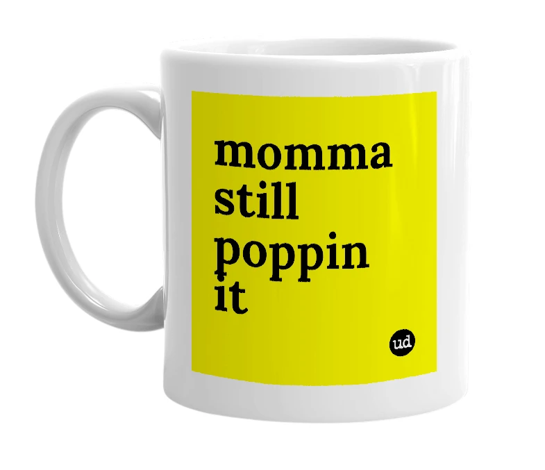 White mug with 'momma still poppin it' in bold black letters