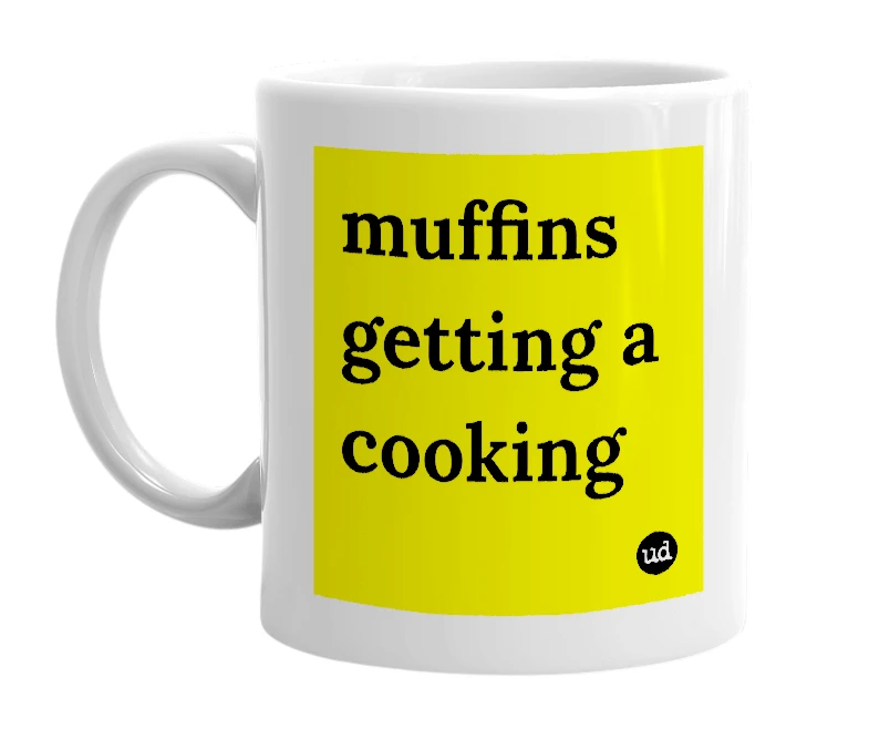 White mug with 'muffins getting a cooking' in bold black letters