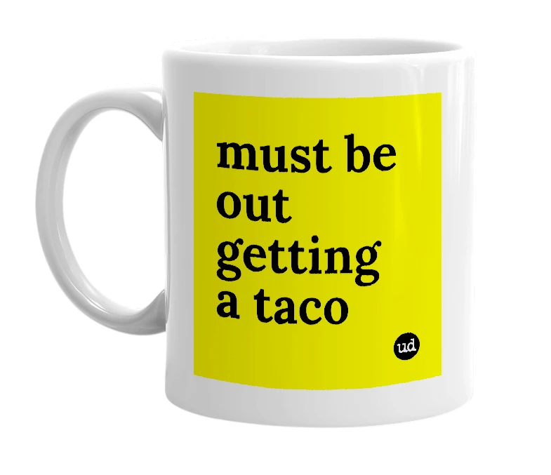 White mug with 'must be out getting a taco' in bold black letters