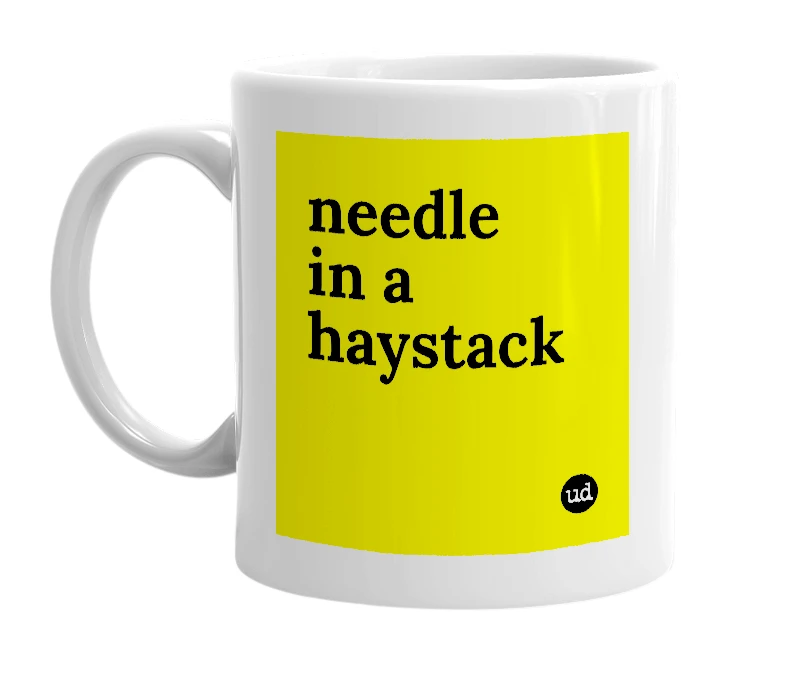 White mug with 'needle in a haystack' in bold black letters