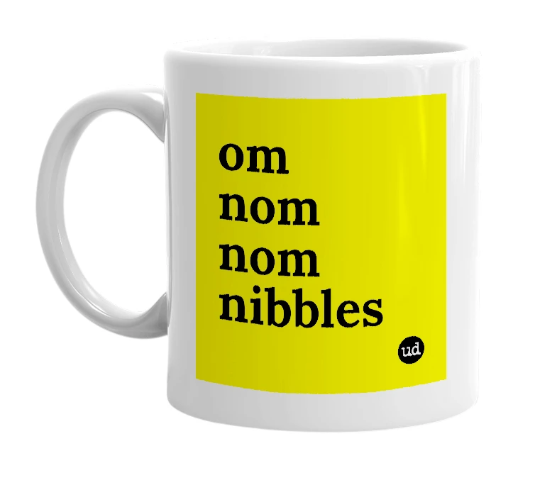 White mug with 'om nom nom nibbles' in bold black letters