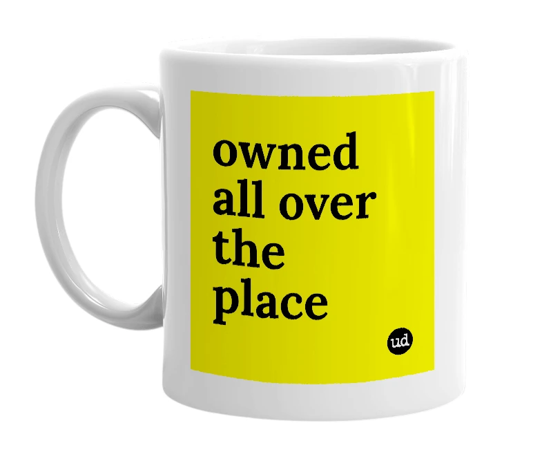 White mug with 'owned all over the place' in bold black letters