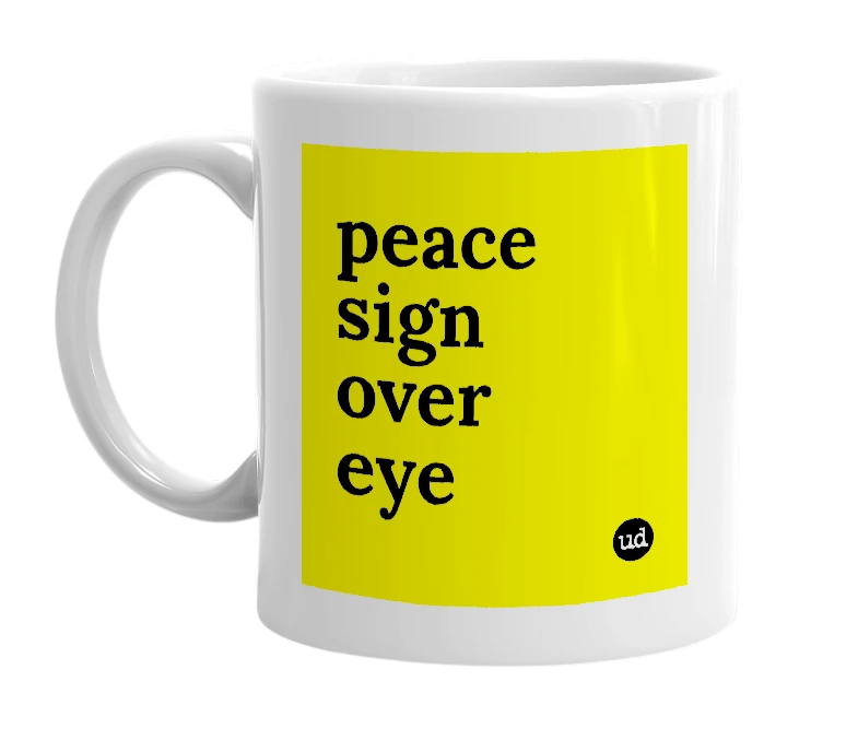 White mug with 'peace sign over eye' in bold black letters