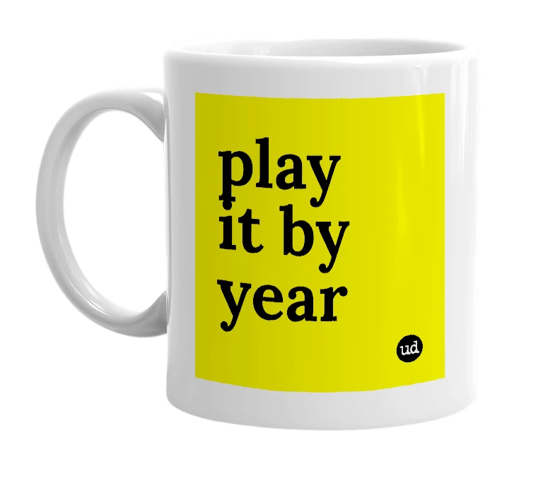 White mug with 'play it by year' in bold black letters