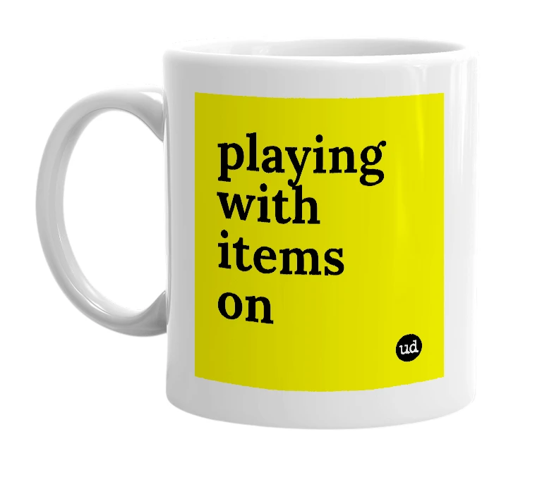 White mug with 'playing with items on' in bold black letters