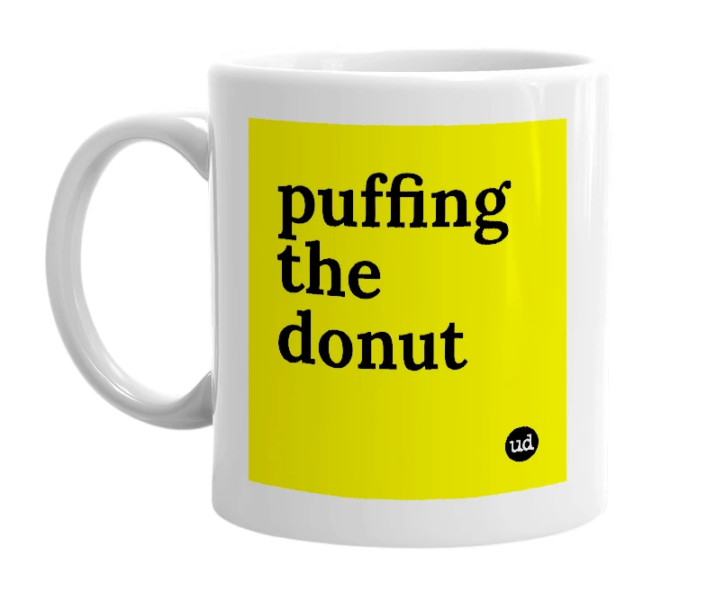 White mug with 'puffing the donut' in bold black letters