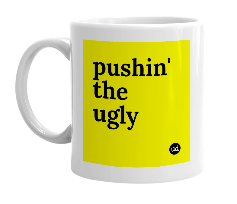 White mug with 'pushin' the ugly' in bold black letters