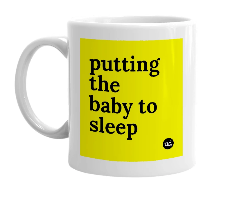 White mug with 'putting the baby to sleep' in bold black letters