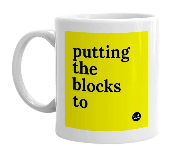 White mug with 'putting the blocks to' in bold black letters