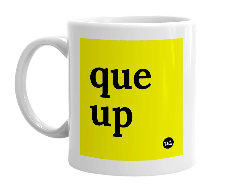 White mug with 'que up' in bold black letters