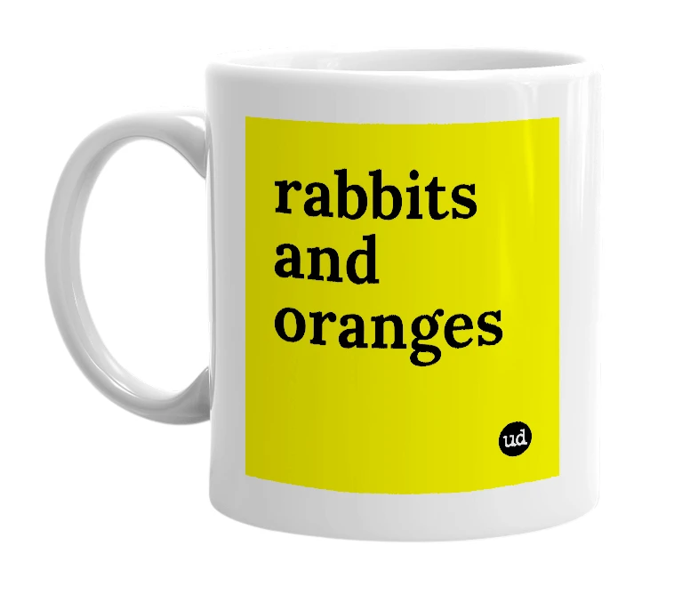 White mug with 'rabbits and oranges' in bold black letters