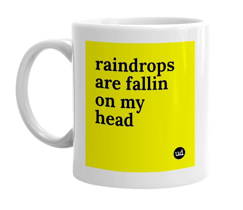 White mug with 'raindrops are fallin on my head' in bold black letters