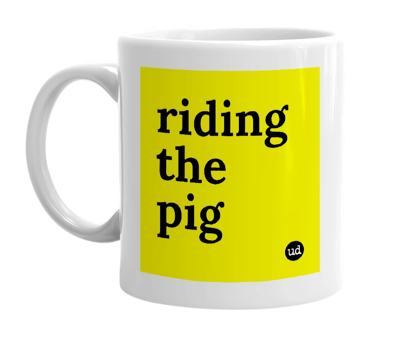White mug with 'riding the pig' in bold black letters