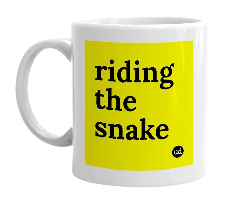 White mug with 'riding the snake' in bold black letters