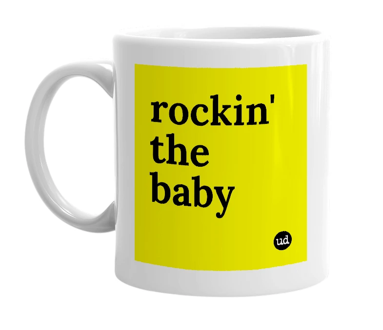 White mug with 'rockin' the baby' in bold black letters