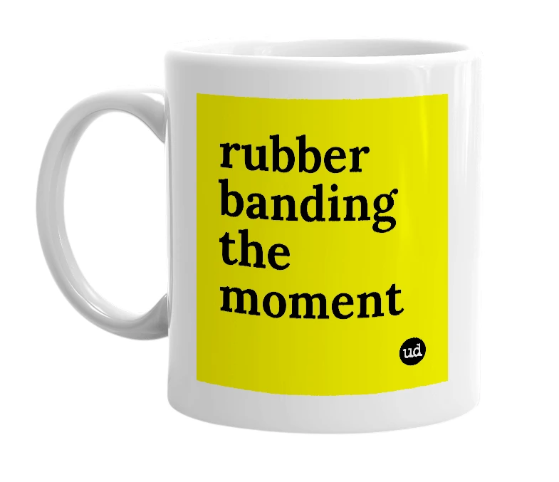 White mug with 'rubber banding the moment' in bold black letters