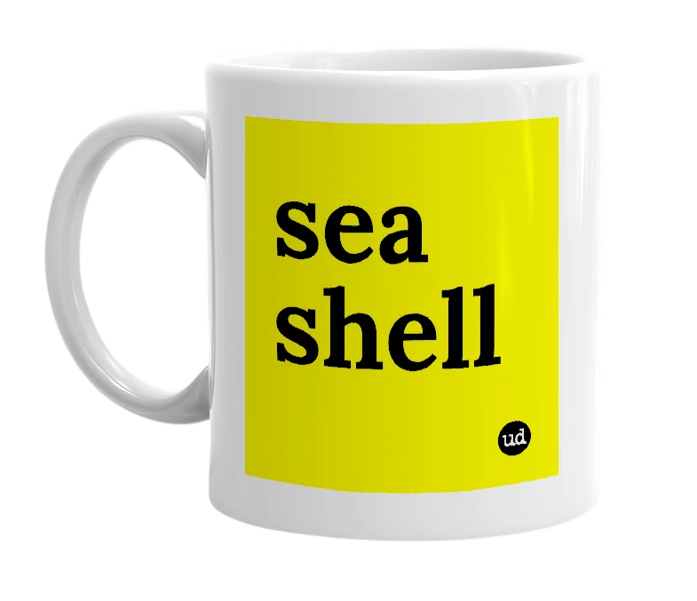 White mug with 'sea shell' in bold black letters