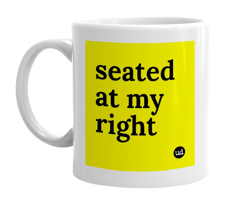 White mug with 'seated at my right' in bold black letters